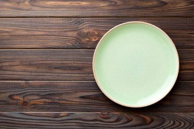 Ahşap zemindeki boş mavi tabağın üst görüntüsü. Tasarımın için boş boşluk.