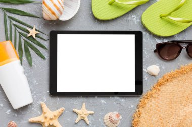 Renkli arka planda tablet ve plaj aksesuarlarıyla düz kompozisyon. Boş ekran ile tablet bilgisayarı kopyalama alanı ile maket.