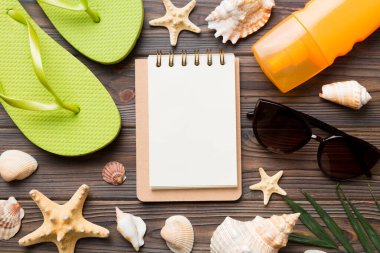 Arka planda plaj aksesuarları olan boş bir kitap, kopyalama alanı. Kopyalama alanı olan düz.