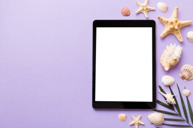 Renkli arka planda tablet ve plaj aksesuarlarıyla düz kompozisyon. Boş ekran ile tablet bilgisayarı kopyalama alanı ile maket.