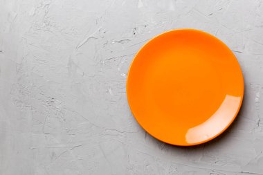 Çimento arka planındaki boş turuncu plakanın üst görüntüsü. Tasarımın için boş boşluk.