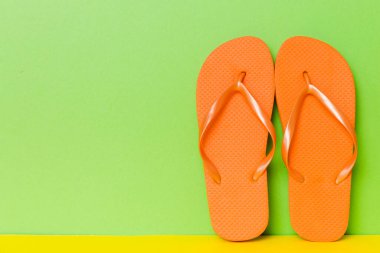 Plaj aksesuarları. Renkli arka planda parmak arası terlik ve denizyıldızı. Kopyalama alanı kullan.