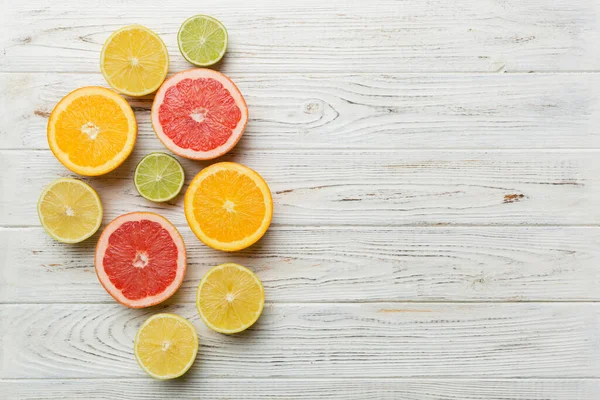 Meyve arkaplanı. Renkli masada renkli taze meyveler. Portakal, limon, greyfurt. Sağlıklı yazı kavramı için. Düz konum, üst görünüm, kopyalama alanı.