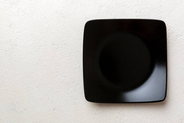 Top view of empty square plate on cement background. Empty space for your design.