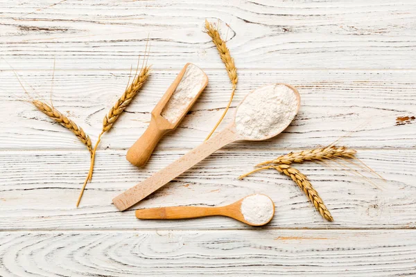 Tahta kasede buğday unu ve renkli arka planda buğday dikenleri. dünya buğday krizi.