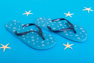 Plaj aksesuarları. Renkli arka planda parmak arası terlik ve denizyıldızı. Üst görünüm Kopyalama alanı ile modelle.