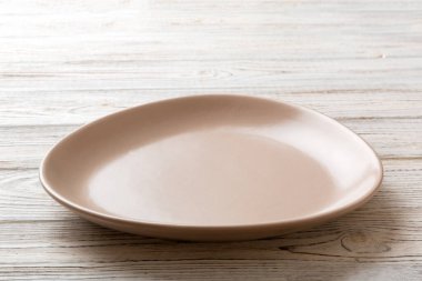 Ahşap arka planda boş pembe plaka manzarası. Tasarımın için boş boşluk.