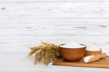 Tahta kasede buğday unu ve renkli arka planda buğday dikenleri. dünya buğday krizi.