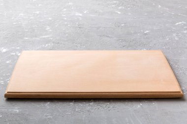 Çimento arka planında tahta kesme tahtası manzarası. Tasarımın için boş boşluk.