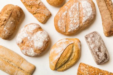 Ev yapımı doğal ekmek. Arka plan olarak farklı taze ekmek türleri, kopya alanı ile üst görünüm.
