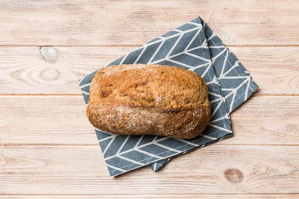 Taze ev yapımı tam buğday ekmeği. Peçetedeki ekmek kırsal arka planda, taze ekmek üst görünümü.
