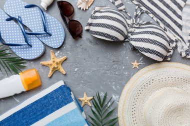 Kadın mayo ve plaj aksesuarları renkli arka plan yaz seyahati konseptine düz bir görünüm kazandırıyordu. Bikini mayo, hasır şapka ve deniz topuklu ayakkabı. Üst görünümü kopyala.