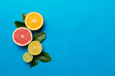 Meyve arkaplanı. Renkli masada renkli taze meyveler. Portakal, limon, greyfurt. Sağlıklı yazı kavramı için. Düz konum, üst görünüm, kopyalama alanı.