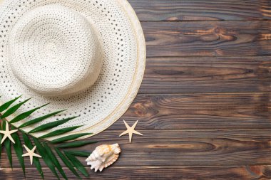 Summer holidays. Summer concept with straw hat and tropical leaf. Flat lay, top view, copy space.