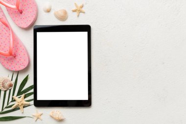 Renkli arka planda tablet ve plaj aksesuarlarıyla düz kompozisyon. Boş ekran ile tablet bilgisayarı kopyalama alanı ile maket.