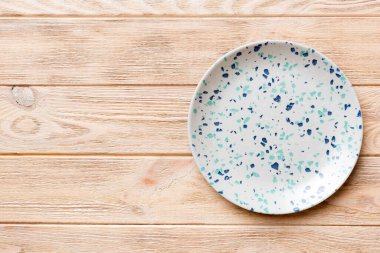 Ahşap zemindeki boş mavi tabağın üst görüntüsü. Tasarımın için boş boşluk.