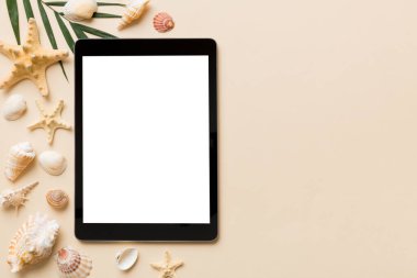 Renkli arka planda tablet ve plaj aksesuarlarıyla düz kompozisyon. Boş ekran ile tablet bilgisayarı kopyalama alanı ile maket.