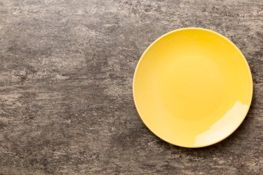 Çimento arka planındaki boş sarı plakanın üst görüntüsü. Tasarımın için boş boşluk.