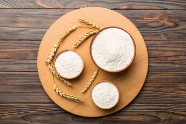 Tahta kasede buğday unu ve renkli arka planda buğday dikenleri. dünya buğday krizi.