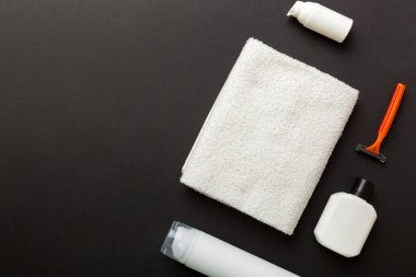 Tıraş Adam seti. Traş makinesi, havlu, losyon ve renkli arka planda tıraş köpüğü. Erkekler banyo aksesuarları üst görünüm.