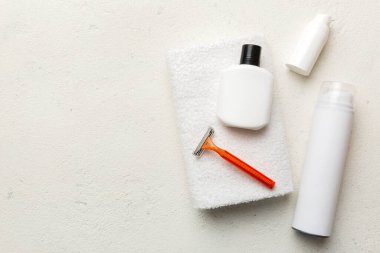 Tıraş Adam seti. Traş makinesi, havlu, losyon ve renkli arka planda tıraş köpüğü. Erkekler banyo aksesuarları üst görünüm.