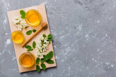 Akasya çiçekli ve yapraklı bal kavanozu. Taze bal üst görünüm düz yatıyordu.