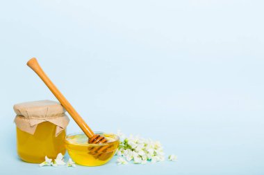 robinia honey bollte with acacacia flomes on color table.