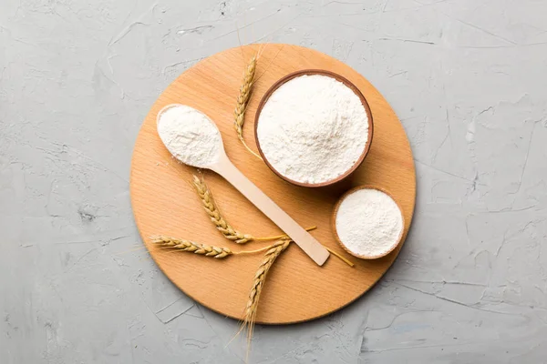 Tahta kasede buğday unu ve renkli arka planda buğday dikenleri. dünya buğday krizi.