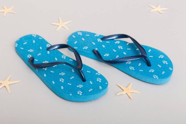 Plaj aksesuarları. Renkli arka planda parmak arası terlik ve denizyıldızı. Üst görünüm Kopyalama alanı ile modelle.