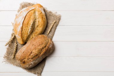 Kırsal masa manzaralı peçeteli taze pişmiş ekmek çeşitleri. Sağlıklı mayasız ekmek. Fransız ekmeği.