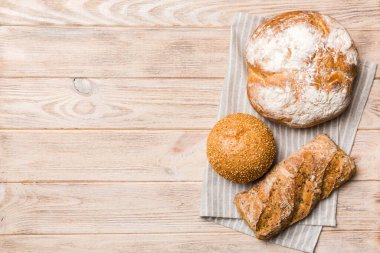 Kırsal masa manzaralı peçeteli taze pişmiş ekmek çeşitleri. Sağlıklı mayasız ekmek. Fransız ekmeği.