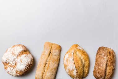 Ev yapımı doğal ekmek. Arka plan olarak farklı taze ekmek türleri, kopya alanı ile üst görünüm.