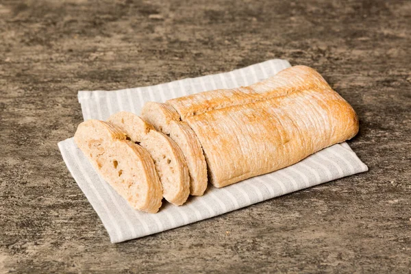 素朴なテーブルの上にナプキンで焼きたてのパンの盛り合わせ 無病息災のパン フランスパンのスライス — ストック写真