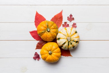 Sonbahar kompozisyonu. Masadaki kurumuş yapraklar ve diğer tasarım aksesuarlarından oluşan desen. Düz yatış, üst görünüm.