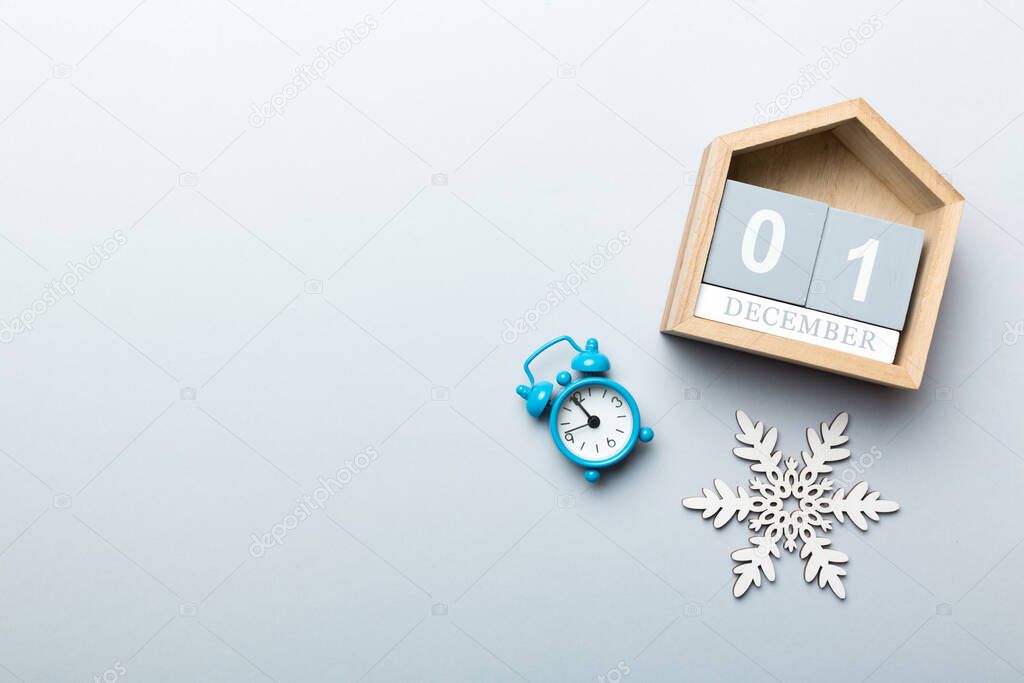 Christmas wood calendar with new year decorations, aganist colored background. Christmas calendar 1 december.