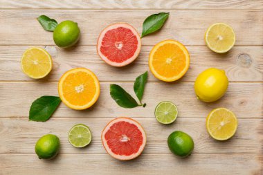 Limon, portakal ve limon gibi açık renkli arka planda limon ağacı yapraklı turunçgil meyveleri. Sağlıklı metin kavramı için alan. Üst görünüm.