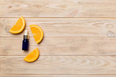 Portakal meyveli şişeler ahşap arka planda gerekli yağ. Kopyalama alanı olan alternatif tıp üst görünümü.