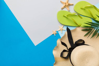 Plaj aksesuarları hasır şapka ve deniz kabuğu renkli masada. Yaz konsepti arka planı.