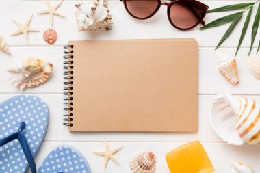 Arka planda plaj aksesuarları olan boş bir kitap, kopyalama alanı. Kopyalama alanı olan düz.