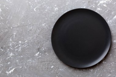 Çimento arka planındaki siyah plakanın üst görüntüsü. Tasarımın için boş boşluk.