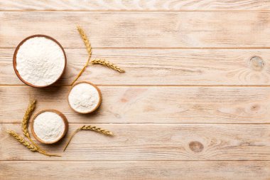 Tahta kasede buğday unu ve renkli arka planda buğday dikenleri. dünya buğday krizi.