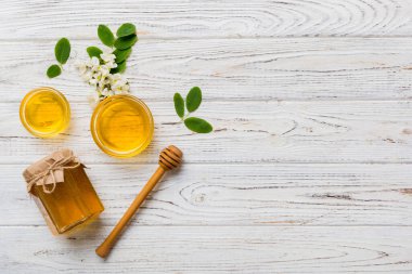 Akasya çiçekli ve yapraklı bal kavanozu. Taze bal üst görünüm düz yatıyordu.