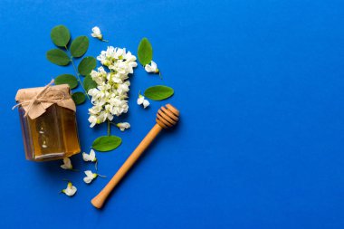 Akasya çiçekli ve yapraklı bal kavanozu. Taze bal üst görünüm düz yatıyordu.