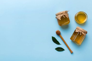 Bal kavanozu, beyaz arka plan manzaralı ve fotokopi alanı olan ahşap bal kaplama. Lezzetli bal şişesi.