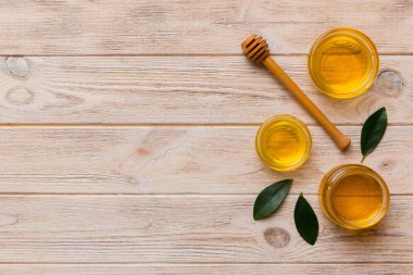 Bal kavanozu, beyaz arka plan manzaralı ve fotokopi alanı olan ahşap bal kaplama. Lezzetli bal şişesi.