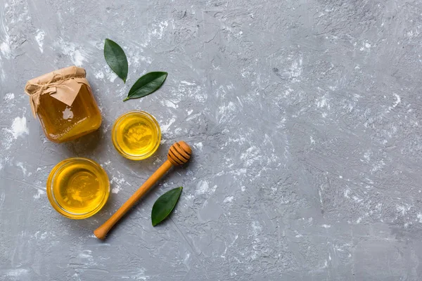 Bal kavanozu, beyaz arka plan manzaralı ve fotokopi alanı olan ahşap bal kaplama. Lezzetli bal şişesi.