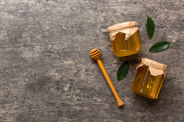 Bal kavanozu, beyaz arka plan manzaralı ve fotokopi alanı olan ahşap bal kaplama. Lezzetli bal şişesi.