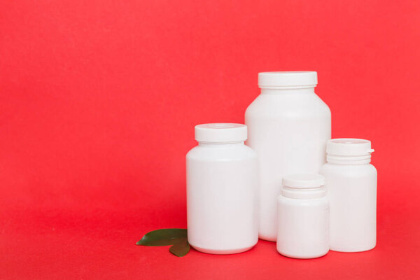 supplement pills with medicine bottle health care and medical top view. Vitamin tablets. Top view mockup bottle for pills and vitamins with green leaves, natural organic bio supplement, copy space.