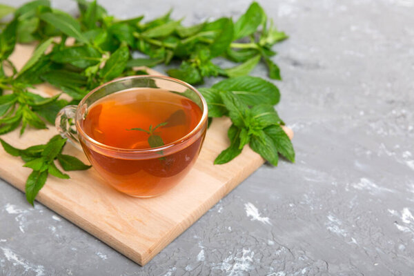 Чашка мятного чая на фоне стола. Зеленый чай со свежим мятным видом сверху с копировальным пространством.