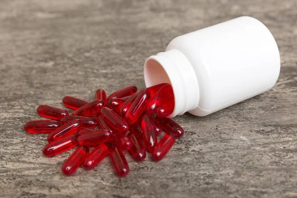 different drugs and health supplement pills poured from a medicine bottle health care and medical top view on colored background.